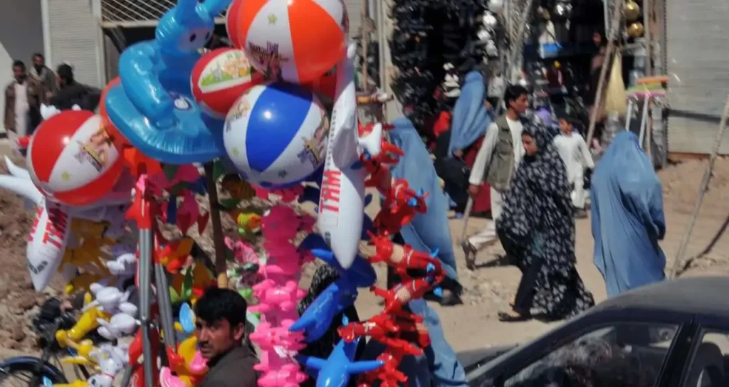an afghan sells inflatable toys in herat city march
